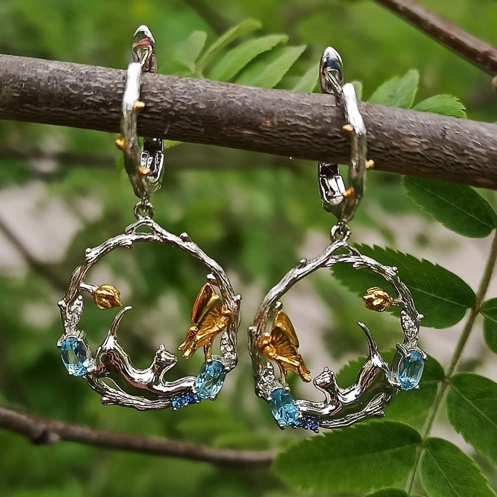 Featuring gold dangle earrings with gorgeous Swiss blue Topaz stones